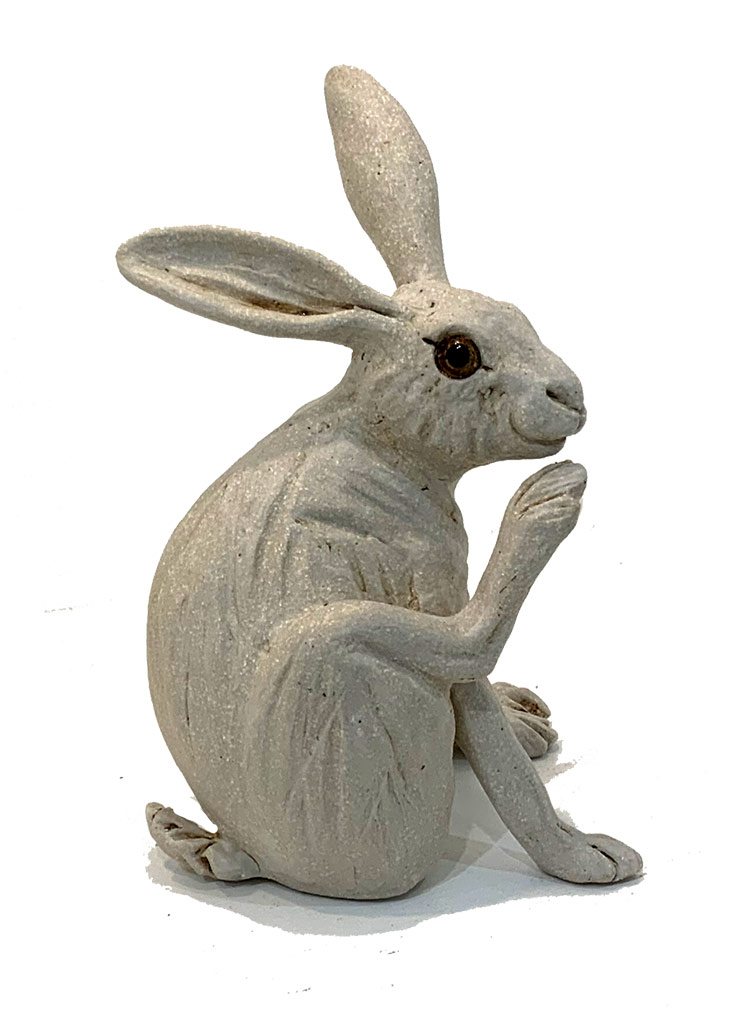 Grooming white hare by Pippa Hill. This small white ceramic hare from Pippa Hill is exhibited at Norton Way Gallery Hertfordshire.