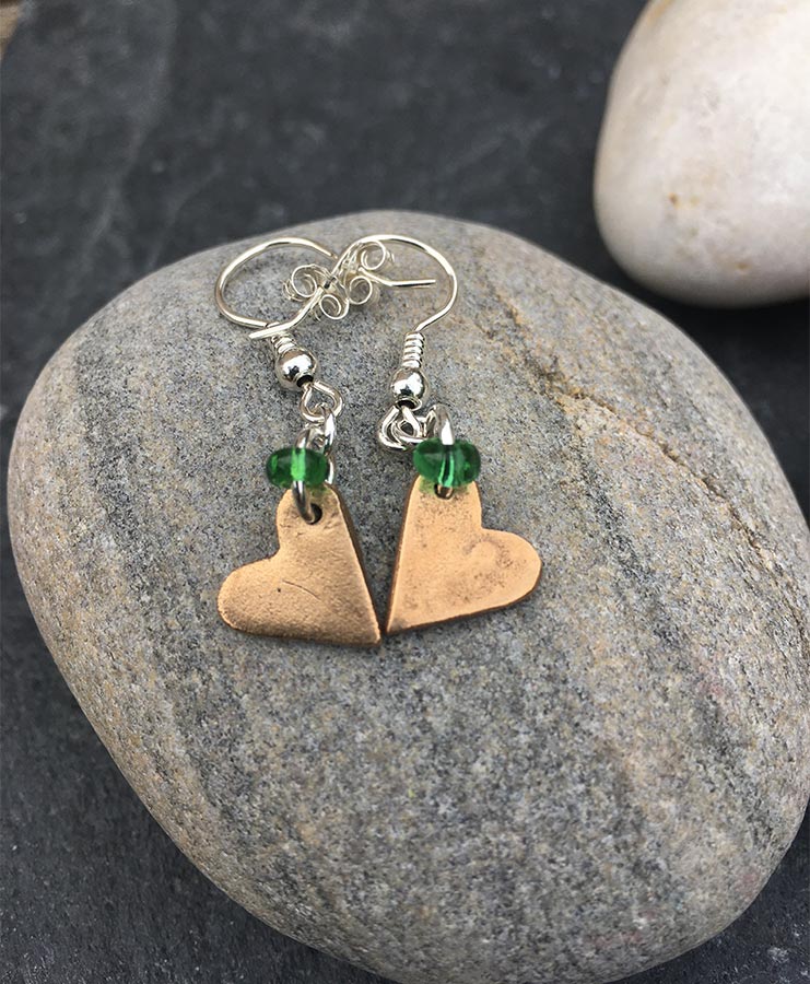 Sarah Cain at Norton Way Gallery, Hertfordshire. This original artwork by British artist, Sarah Cain is created in bronze. It is a beautiful pair of earrings, comprising green glass beads and bronze. They depict hearts. A piece of jewellery.