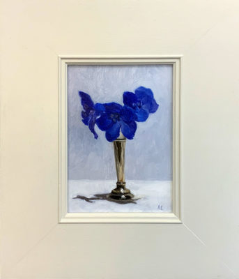Original artwork by Rosemary Lewis. This original oil painting by Rosemary Lewis depicts stunning deep blue Delphiniums, in a silver vase. It is exhibited at Norton Way Gallery Hertfordshire. Its framed in a simple, contemporary off white frame.