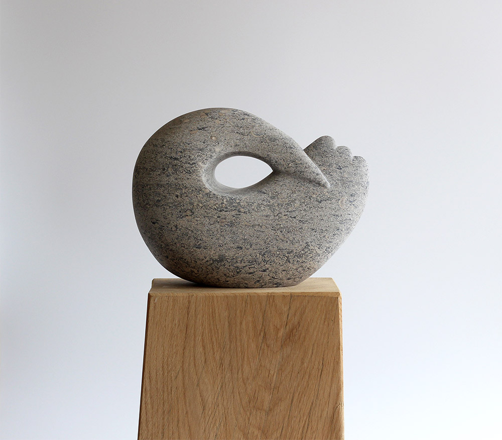 Jennifer Tetlow: This beautiful stone carving, sculpture by Jennifer Tetlow represents a lsymbolic sperically designed bird. Each piece of Jennifer Tetlow sculpture is individually carverd from, this one from an oolitic limestone.It is exhibited at Norton Way Gallery Hertfordshire.