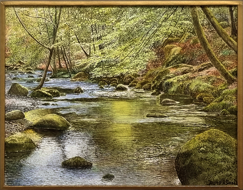 Rosalind Pierson art at Norton Way Gallery Hertfordshire. This beautiful, miniature, painting has been painted in watercolour. It is an original artwork from Rosalind Pierson and depicts a shaded summer river. There are trees and bolders..