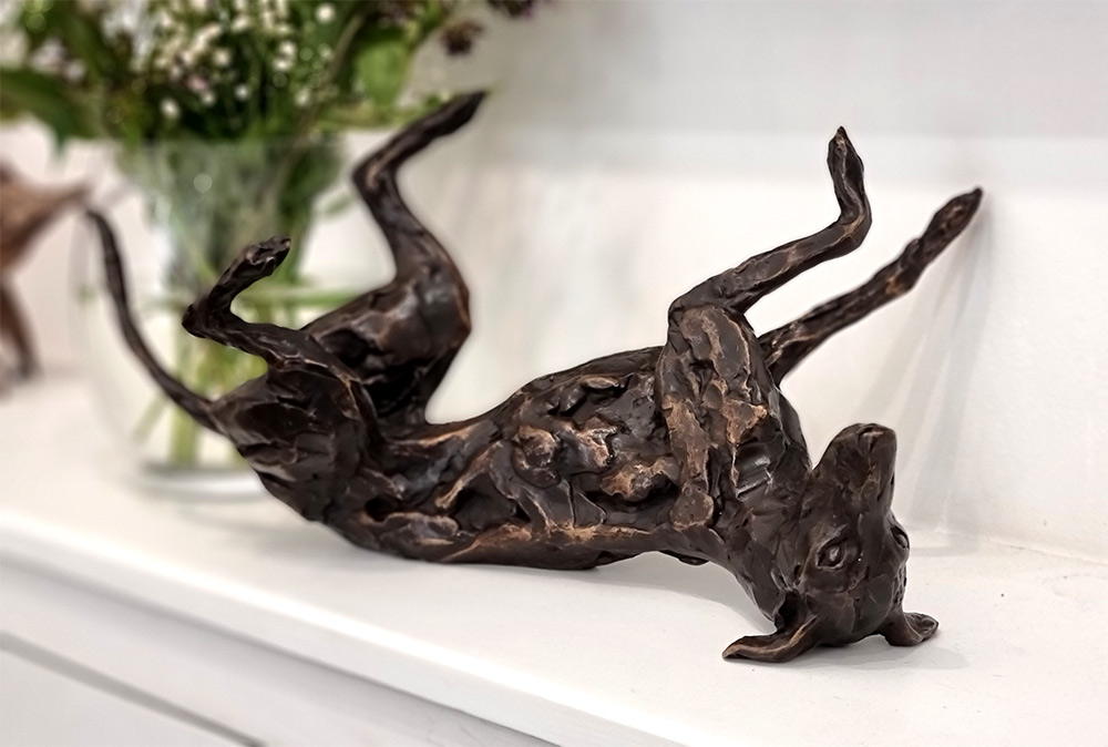 Stuart Anderson at Norton Way Gallery Hertfordshire. This beautiful foundry bronze sculpture from Stuart Anderson is an original artwork. It depicts a sighthound, which could be a greyhound or lurcher, rolling on its back.