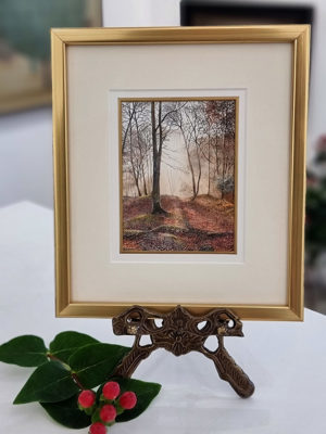 Rosalind Pierson art at Norton Way Gallery Hertfordshire. This beautiful, miniature, painting has been painted in watercolour. It is an original artwork from British artist Rosalind Pierson and depicts a shaded woodland scen in autumn. It is framed in a slim gold frame.