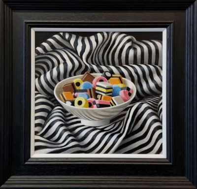 Anne Songhurst Art at Norton Way Gallery Hertfordshire. This beautiful oil painting is an original artwork by British artist Anne Songhurst. It is a still life painting, depicting a white bowl of Liquorice Allsorts on black and white, striped material.