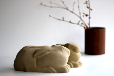 Jennifer Tetlow sculpture at Norton Way Gallery Hertfordshire. This beautiful stone carving, from Jennifer Tetlow is carved from Yourkstone. It depicts a symbolic, two beautiful small hares or leverets, huddled down .