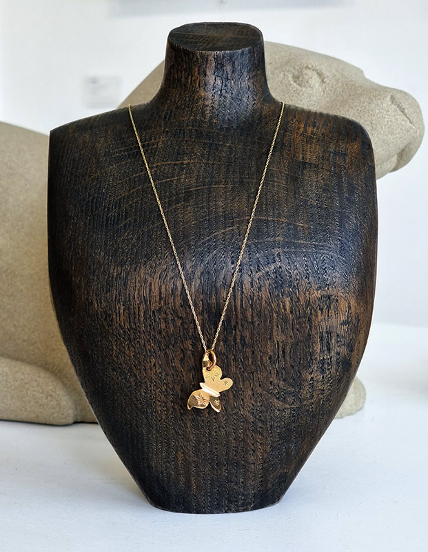 Lou Shotter at Norton Way Gallery, Hertfordshire. This original artwork by British artist, Lou Shotter is created in eighteen carat gold. It is a gold pendant depicting a gold butterful. A piece of jewellery.
