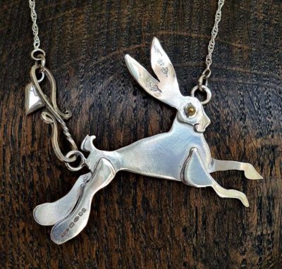 Lou Shotter at Norton Way Gallery, Hertfordshire. This original artwork by British artist, Lou Shotter is created in Stirling Silver. It is a pendant depicting a silver hare. A piece of jewellery.