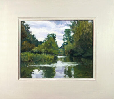 Rosemary Lewis at Norton Way Gallery, Hertfordshire. This original artwork by British artist, Rosemary Lewis is painted in oils. It depicts a beautiful lake reflecting the trees and bushes, that surround it. This original painting is framed in a hand painted, off white frame.