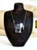 Lou Shotter at Norton Way Gallery, Hertfordshire. This original artwork by British artist, Lou Shotter is created in Stirling Silver. It is a pendant depicting a silver elephant. A piece of jewellery.